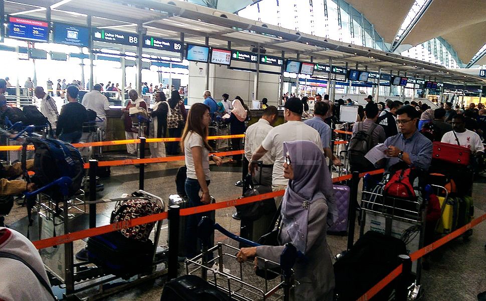 Passengers lining up at check-in counters at KLIA