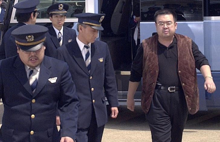A man (R) believed to be North Korean heir-apparent Kim Jong Nam, is escorted by police as he boards a plane upon his deportation from Japan at Tokyo's Narita international airport in Narita, Japan, in this photo taken by Kyodo May 4, 2001. Picture taken May 4, 2001. Mandatory credit Kyodo/via REUTERS/Files