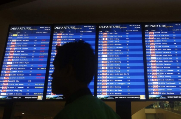 File picture of a man walking in front of a flight board at klia2 in Sepang April 30, 2014. - Reuters pic