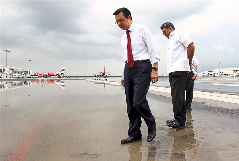 Check-up: Liow (left) inspecting the waterlogged tarmac of the taxiway with Badlisham during his visit to klia2 in Sepang. ?MOHD SAHAR MISNI / The Star