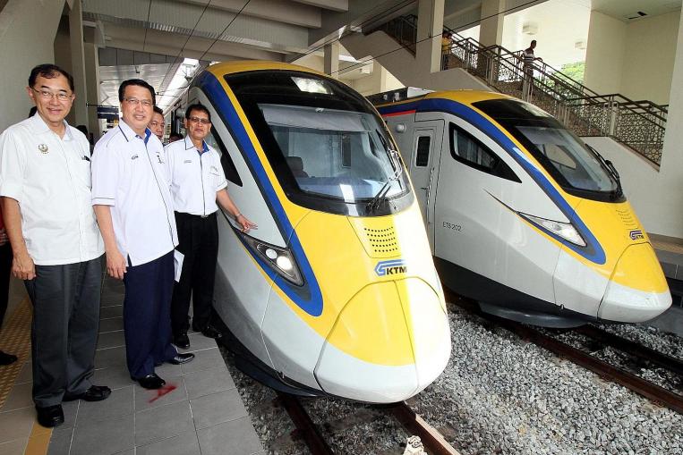 Council member Mah Hang Soon and Malaysian Transport Minister Liow Tiong Lai join KTM president Sarbini Tijan as he checks out the new electric trains.