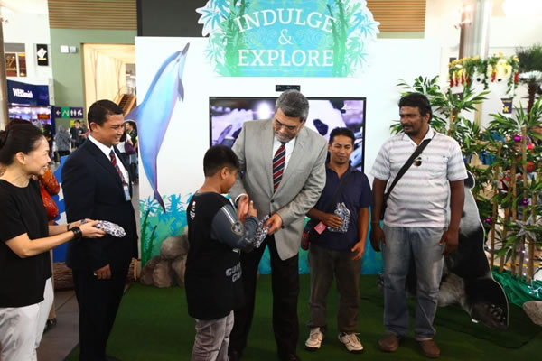 Malaysia Airports Managing Director Datuk Badlisham Ghazali presents prizes to winners of the 'Indulge and Explore' kinetic games