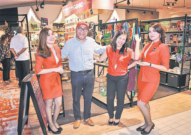 AirAsia X CEO Datuk Kamarudin Meranun (second left) posing with Yap (second right) and two staff after the launch of Destination: GOOD pop-up shop at klia2.