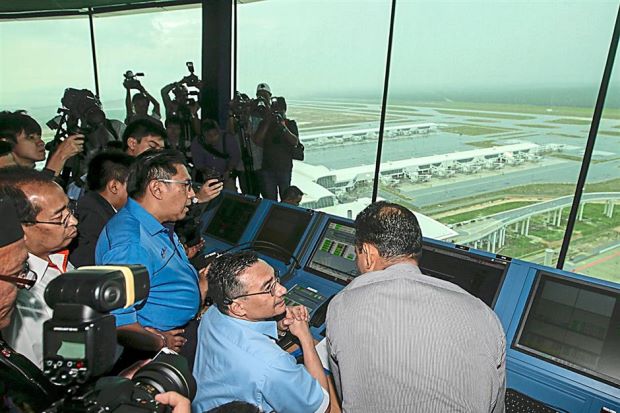 Ready for operatio ns: Hishammuddin and Department of Civil Aviation director-general Datuk Azharuddin Abdul Rahman (third from right) being briefed during the handover ceremony at Kuala Lumpur International Airport in Sepang. ?EPA