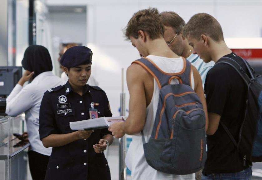 A police officer checks the travel documents and passports of passengers at Kuala Lumpur International Airport in Sepang March 9, 2014. — Reuters pic