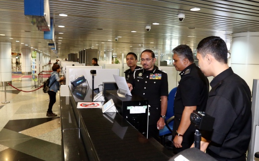 Immigration Director-General Datuk Seri Mustafar Ali (third from right) speaking with his officers during a visit at Kuala Lumpur International Airport counter recently
