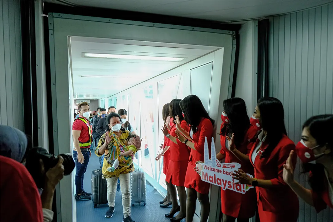 AirAsia staff welcome passengers disembarking from a flight at Kuala Lumpur International Airport on April 1.Photographer: Samsul Said/Bloomberg