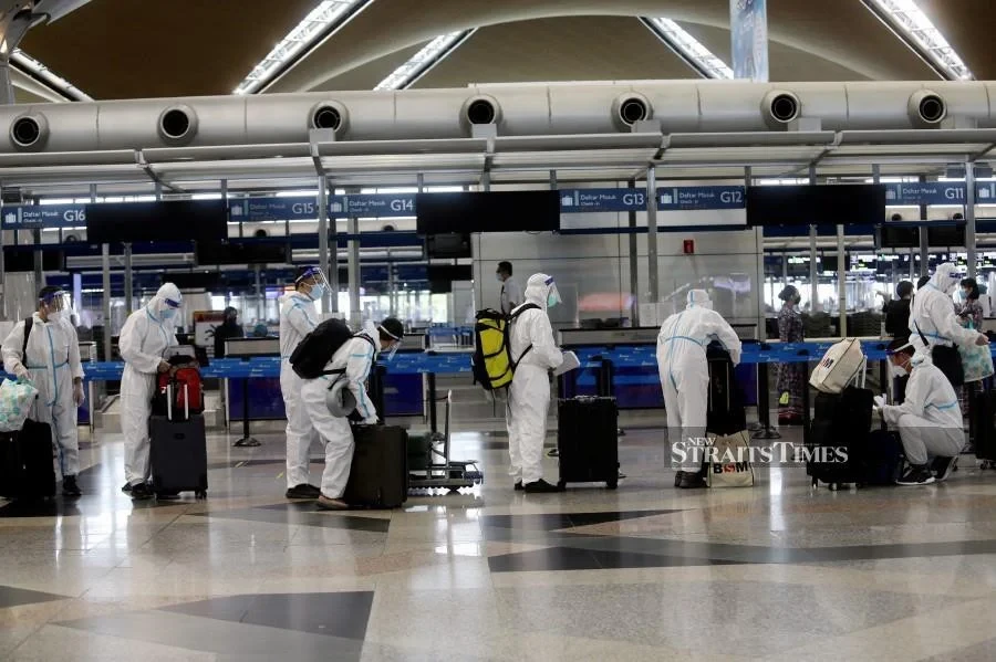 Several passengers seen wearing the personal protective equipment (PPE), while lining up at the check-in counters at the Kuala Lumpur International Airport today. - NSTP/MOHD FADLI HAMZAH