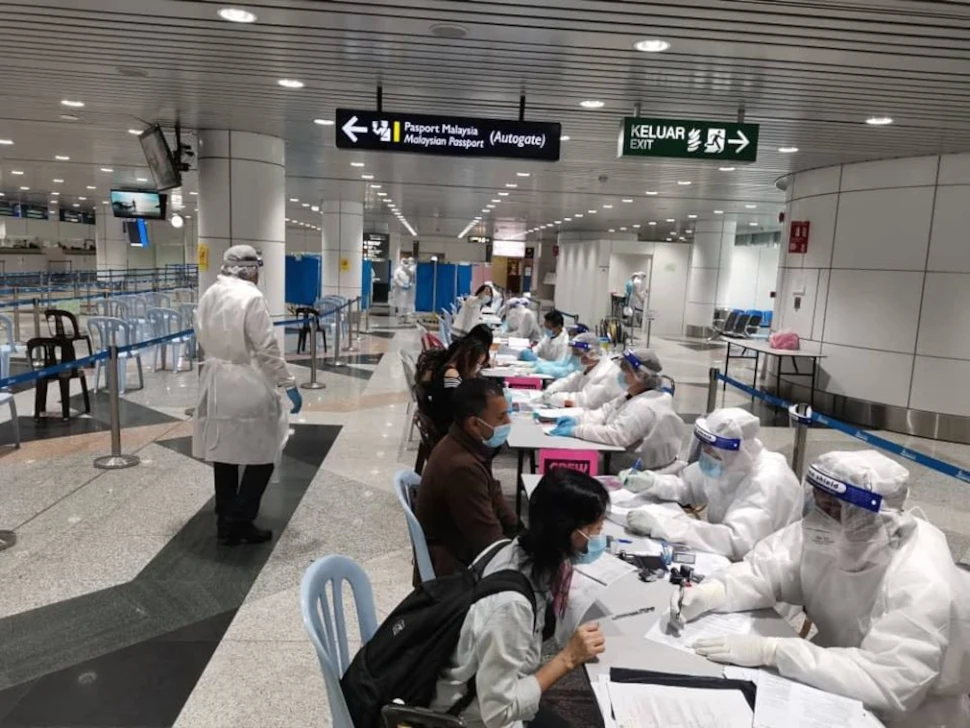 Health care workers registering arrivals for Covid-19 contact tracing at an airport in Malaysia. Picture from Facebook @DGHisham.