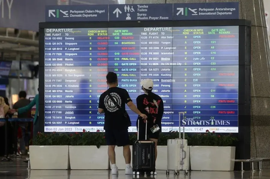 Travellers looking at the flight information display system in KLIA. - NSTP/MOHD FADLI HAMZAH