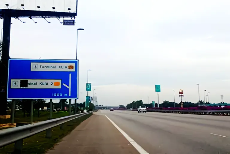 After the KLIA toll plaza, signboard and Petronas station in view