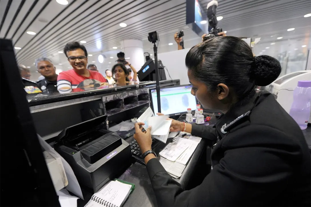 An Immigration Department officer checking the travel documents of tourists at KLIA.