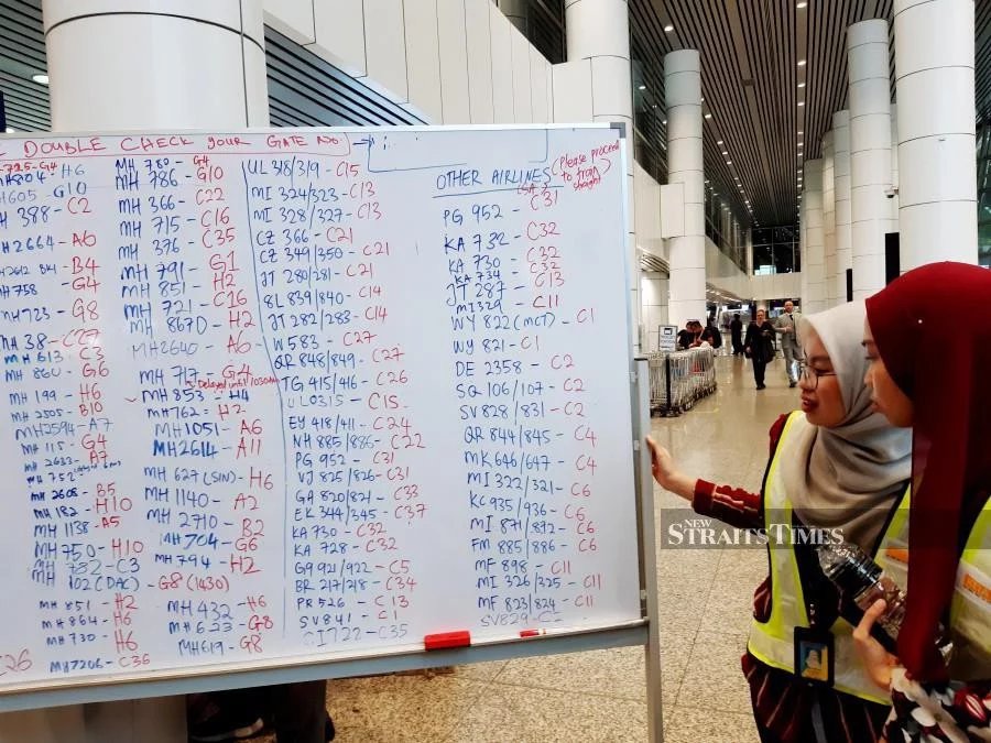 Departure gate information for passengers written on whiteboards at the Kuala Lumpur International Airport yesterday. - NSTP