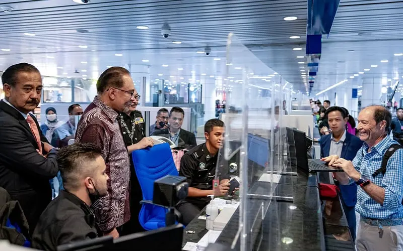 Prime Minister Anwar Ibrahim interacting with passengers and immigration staff during his ‘surprise’ visit to KLIA today. (Facebook pic)