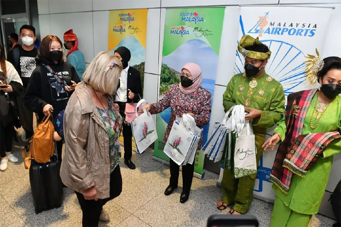 Datuk Seri Nancy Shukri handing out a goody bag to a tourist arriving direct on a Malaysia Airlines flight from Doha, Qatar at the Kuala Lumpur International Airport in Sepang.