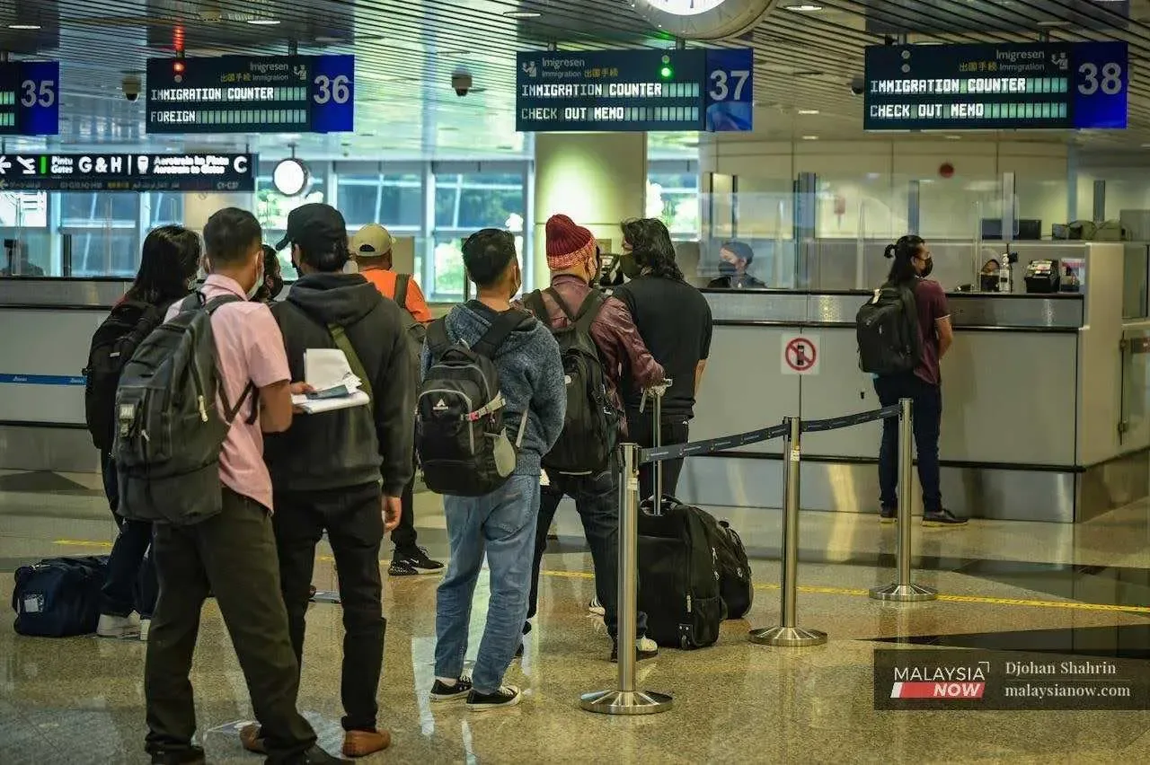 Travellers queue at the immigration counter in KLIA in Sepang. Airlines across the world are struggling with flight delays and cancellations in the wake of the Covid-19 pandemic.