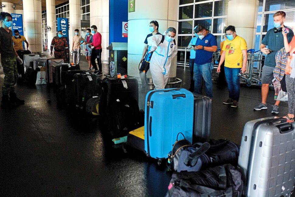 Safety measures: Luggage belonging to passengers who have just arrived at KLIA being sanitised to prevent the spread of Covid-19. — Bernama
