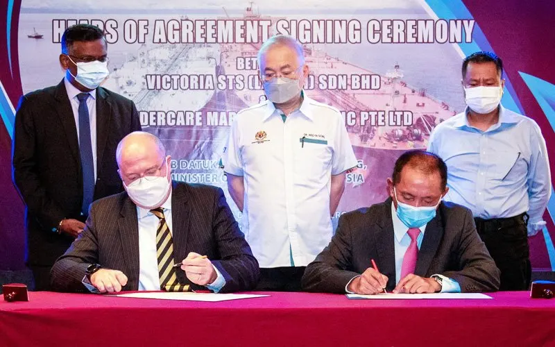 Transport minister Wee Ka Siong (centre) witnessing the signing of the agreement by Victoria STS Labuan Sdn Bhd managing director Benjamin Bijion (sitting, right) and William Barker of Fendercare Marine Asia Pacific Pte Ltd. (Bernama pic)