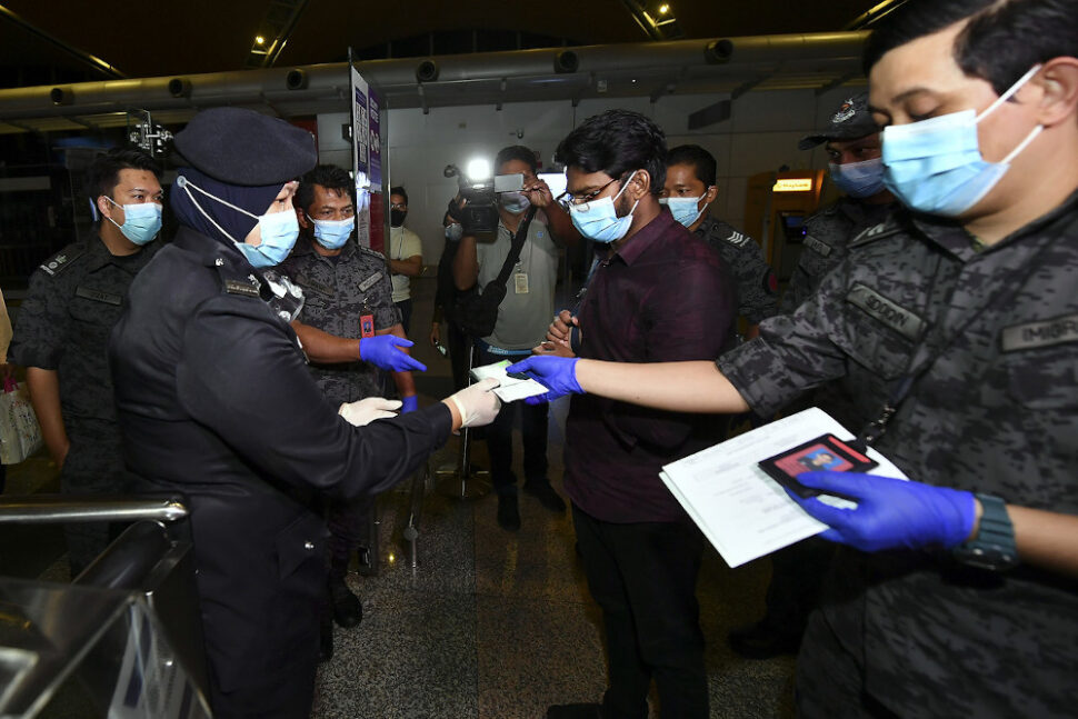 Md Rayhan Kabir getting his travel documents checked by airport security at the Kuala Lumpur International Airport, August 21, 2020. — Bernama pic