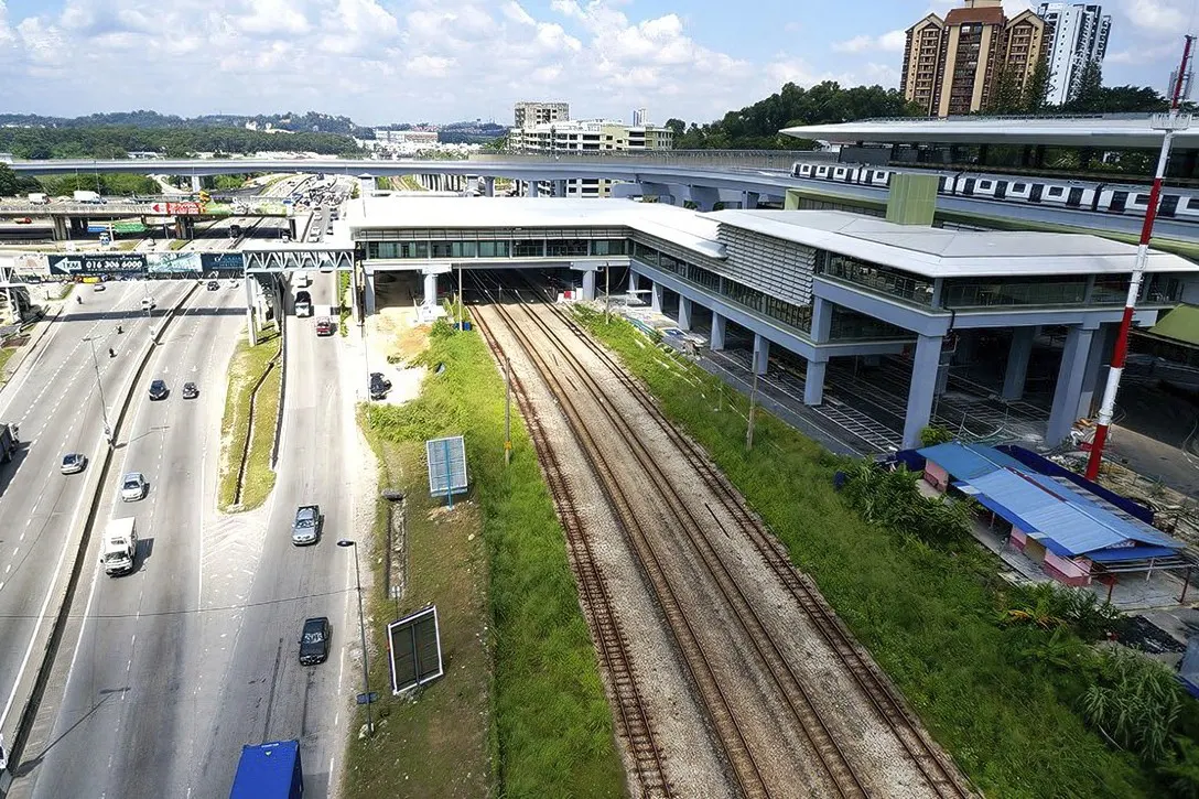 View of the completed Sungai Buloh MRT Station with the common concourse with the Sungai Buloh KTM Station over the KTM tracks. Also seen is an MRT train undergoing testing.
