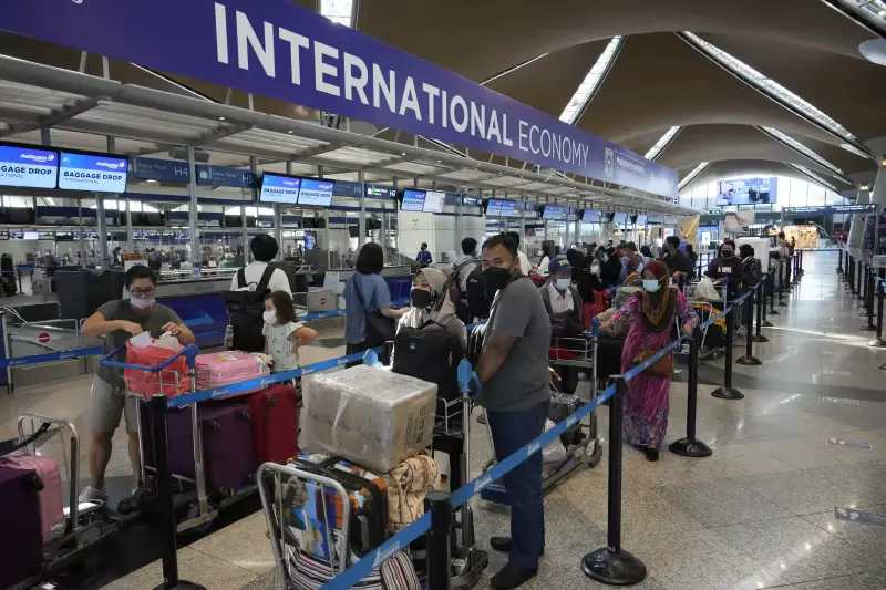 Travelers line up at check in counter at Kuala Lumpur International Airport in Sepang, Malaysia, Friday, April 1, 2022.