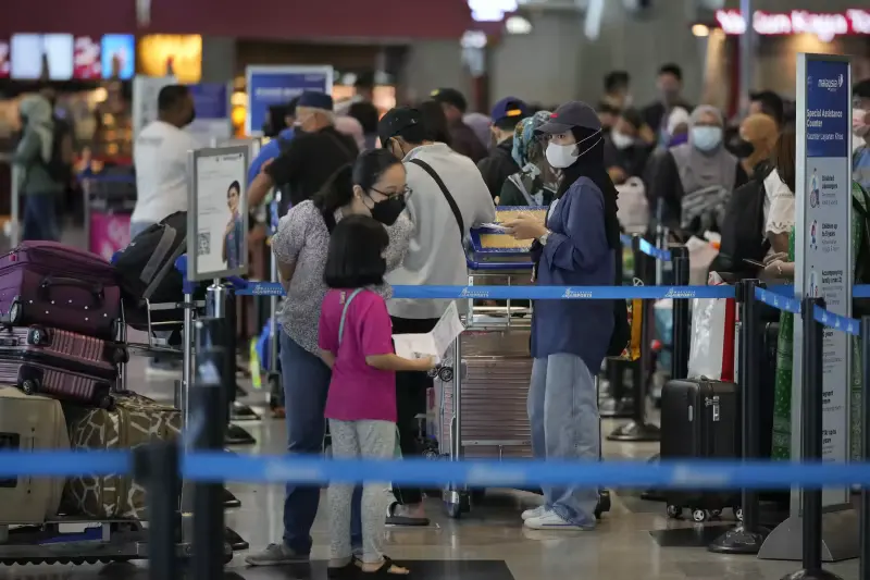 Travelers line up at check in counter at Kuala Lumpur International Airport in Sepang, Malaysia, Friday, April 1, 2022. 