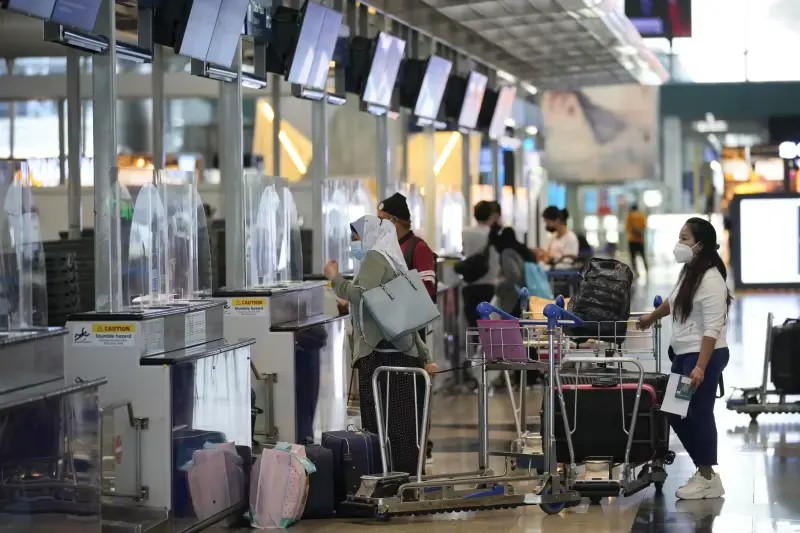 Travelers line up at check in counter at Kuala Lumpur International Airport in Sepang, Malaysia, Friday, April 1, 2022.