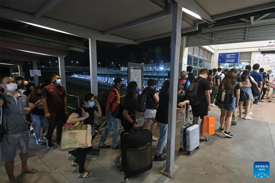 Tourists queue to cross the causeway into Malaysia at Singapore's Woodlands Checkpoint, on the first day of full re-opening of borders between Singapore and Malaysia on April 1, 2022. Malaysia opened its borders to international travel on Friday, ending restrictions that have been in place since the COVID-19 pandemic began in 2020. (Photo by Then Chih Wey/Xinhua)