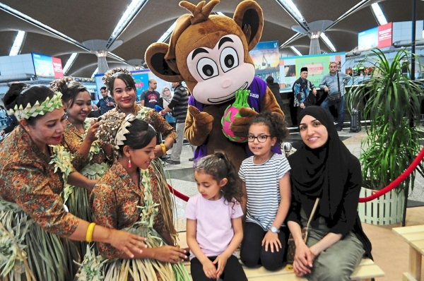French tourists taking a photograph with Mah Meri dancers from Bukit Bangkung and the Visit Sepang Year 2020 mascot.