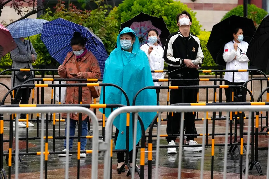Beijing residents lining up in the rain yesterday for their Covid-19 test. Authorities have stepped up efforts to prevent a major outbreak similar to the one in Shanghai. (AP pic)