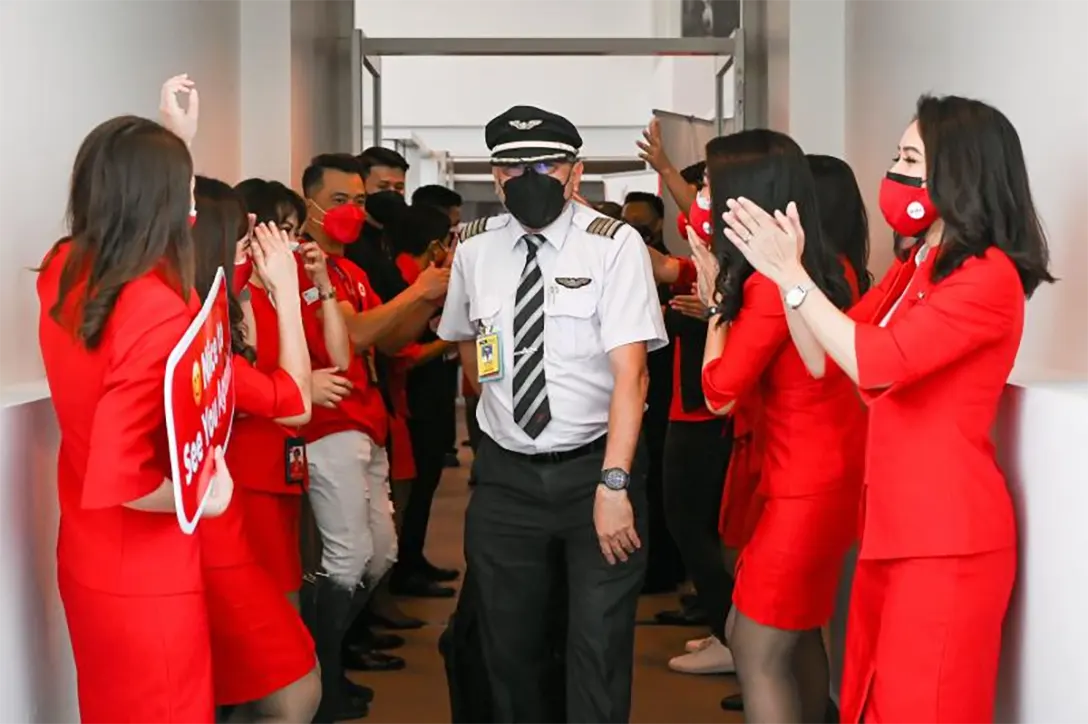 AirAsia flight attendants gesture to a pilot in Kuala Lumpur International Airport 2 (KLIA 2), as Malaysia reopened its borders for travellers fully vaccinated against the Covid-19 coronavirus, in Sepang on April 1, 2022. ((AFP file photo)