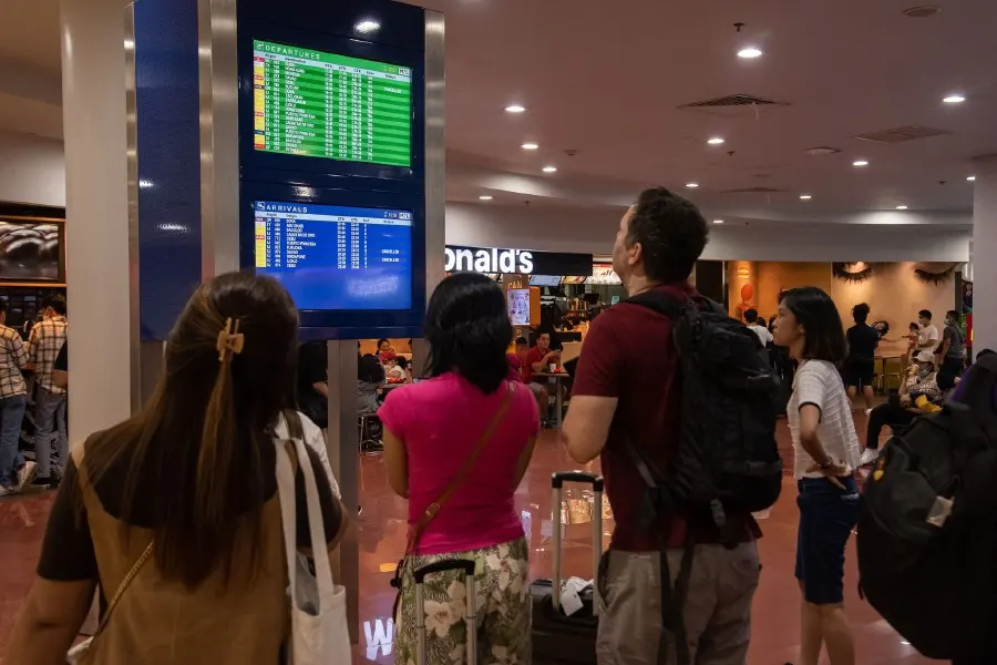 Passengers look at a screen showing flight information at terminal 3 of Ninoy International Airport in Pasay, Metro Manila. - AFP PIC