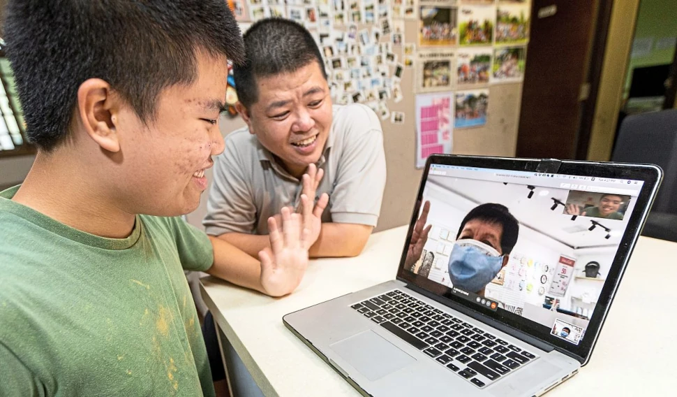 See you soon: Lee Jun Le, 14, (left) is looking forward to meeting his grandmother Tay Sock Hya, 71, (seen on the monitor) in Ulu Tiram, Johor. He and his father Bob Lee are teleconferencing from their home in Jurong, Singapore. — Pic by The Fat Farmer